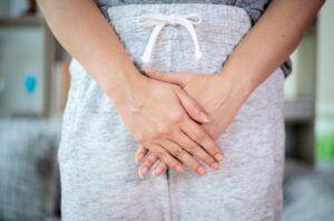 A infecção urinária é uma patologia bastante recorrente nos prontos atendimentos. Mas, ao contrário do que muitas pessoas pensam, não se trata de uma doença que pode ser negligenciada, porque também responde a 30% dos casos de infecção hospitalar. Então, é mais do que importante cuidar o quanto antes. Entenda mais sobre o que é essa patologia, o que causa, sintomas e como tratá-la. O que é e o que causa infecção de urina? A infecção urinária é uma condição que ocorre devido à presença de micro-organismos (bactérias ou fungos) em qualquer parte do trato urinário, trazendo um quadro infeccioso a essa região. O sistema urinário é composto por uretra, ureteres, bexiga e rins: Rins O organismo tem dois desses órgãos localizados nas costas acima da região dos quadris. São responsáveis por filtrar as toxinas do corpo e do sangue. Esses resíduos serão transformados em urina. Ureteres São os tubos finos que transportam a urina dos rins para a bexiga. Bexiga A bexiga é um órgão muscular. Sua principal função é armazenar temporariamente a urina e se contrair para realizar a expulsão do líquido para fora do organismo. Uretra É o pequeno tubo que leva a urina da bexiga para a parte exterior do corpo. Tipos de infecção urinária Em torno de 80% das infecções urinárias afetam o trato urinário inferior, ou seja, a uretra e a bexiga. Quando as bactérias ficam na bexiga, a patologia é conhecida como cistite, e quando estão na uretra, a patologia leva o nome de uretrite. No entanto, quando a infecção urinária atinge o trato superior (rins), a condição pode se tornar mais grave, levando à doença conhecida como pielonefrite, que é potencialmente perigosa para a funcionalidade dos rins. A infecção urinária é 30% mais comum em mulheres do que em homens, devido à anatomia feminina, porque a uretra da mulher é mais curta (4 a 5 cm) e é mais próxima ao ânus, favorecendo que os micro-organismos que são naturais dos intestinos, como a Escherichia Coli, invadam as estruturas que compõem o sistema urinário. Assim, a infecção urinária ocorre em 1 a cada 5 mulheres em alguma fase da vida. Além disso, uma parcela das mulheres também vão sofrer com infecção urinária recorrente, mesmo fazendo os tratamentos corretamente. No entanto, não está descartado que homens e crianças do sexo masculino também sejam afetados. Para os idosos, a infecção urinária está relacionada aos problemas de esvaziamento completo da bexiga, que podem ter a ver com problemas na próstata nos homens ou bexiga caída nas mulheres. A infecção urinária pode ter como fatores de risco: Menopausa, que altera a flora vaginal e o tecido da uretra devido às baixas taxas de estrogênio, favorecendo a entrada dos micro-organismos; Sexo: neste caso, a infecção é conhecida como cistite de lua de mel ou cistite pós-coito, quando os micro-organismos que vivem na vagina e no trato intestinal passam pela uretra e chegam à bexiga a partir de uma relação sexual; Mania de segurar o xixi por muito tempo; Diabetes; Gravidez; Baixa imunidade; Defeitos anatômicos; Uso contínuo de fraldas geriátricas.