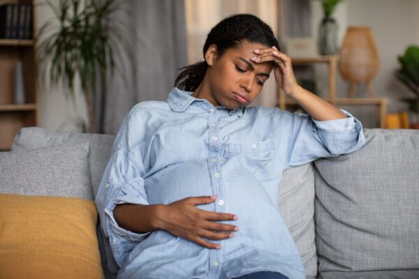 A infecção urinária na gravidez é uma condição mais comum do que as mulheres imaginam. Por isso, é necessário que a grávida faça o acompanhamento médico durante a gestação e fique muito atenta aos sinais do seu corpo porque essas infecções trazem riscos não só para ela mas também ao bebê. Veja neste texto quais são os sintomas de infecção urinária na gravidez e como é possível tratar. O que causa infecção urinária na gravidez? As infecções do trato urinário ocorrem quando as bactérias entram no sistema urinário e se multiplicam na uretra, bexiga, ureteres ou rins. É uma patologia que atinge mais as mulheres. Na gravidez, a infecção urinária é uma condição muito comum, ocorre devido às mudanças no corpo, com o útero em expansão, e também pelo aumento de açúcar na urina e hormônios que relaxam a musculatura uterina, que levam a outras alterações fisiológicas, como a dilatação do ureter e dos cálices renais. Assim, com o útero pressionando a bexiga, a grávida não esvazia completamente o órgão em cada micção, e quanto mais tempo a urina permanece parada, aumentam as chances de colonização de bactérias. O aumento dos hormônios também podem levar a mulher a ter refluxo vesicoureteral, que é uma condição na qual a urina flui de volta da bexiga para os rins e também favorece as infecções urinárias. Há casos em que o refluxo vesicoureteral atinge apenas um ureter (unilateral), mas também pode envolver os dois ureteres (bilateral). Anemia falciforme e diabetes são outras duas patologias que aumentam as chances de uma infecção urinária na gravidez. A grávida pode ter 3 tipos de infecções urinárias: Cistite: quando a infecção está localizada na bexiga; Pielonefrite: é uma infecção urinária que atinge os rins, e é muito mais grave, pode causar danos permanentes nos rins caso não seja tratada; Assintomática: em até 7% dos casos, geralmente no início da gestação, as grávidas podem não manifestar os sintomas da infecção urinária, fazendo com que a patologia não seja devidamente tratada e evolua para uma pielonefrite. Caso não seja tratada, a infecção urinária na gravidez traz riscos para o bebê e para a gestante, como induzir a um trabalho de parto prematuro, aumentar a pressão da mãe, provocar baixo peso do feto, mortalidade perinatal e choque séptico da mulher.